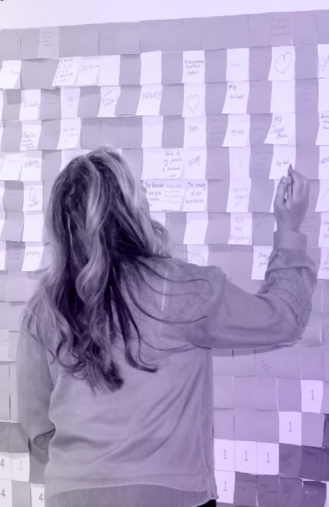 Woman planning with sticky notes organized on a wall