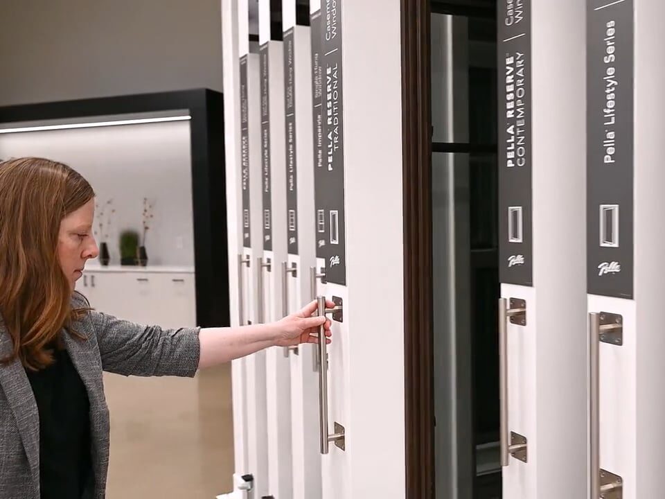 A client reads the information panel as she's about to pull out an interactive Pella window display found on the show floor at retail stores nationwide.