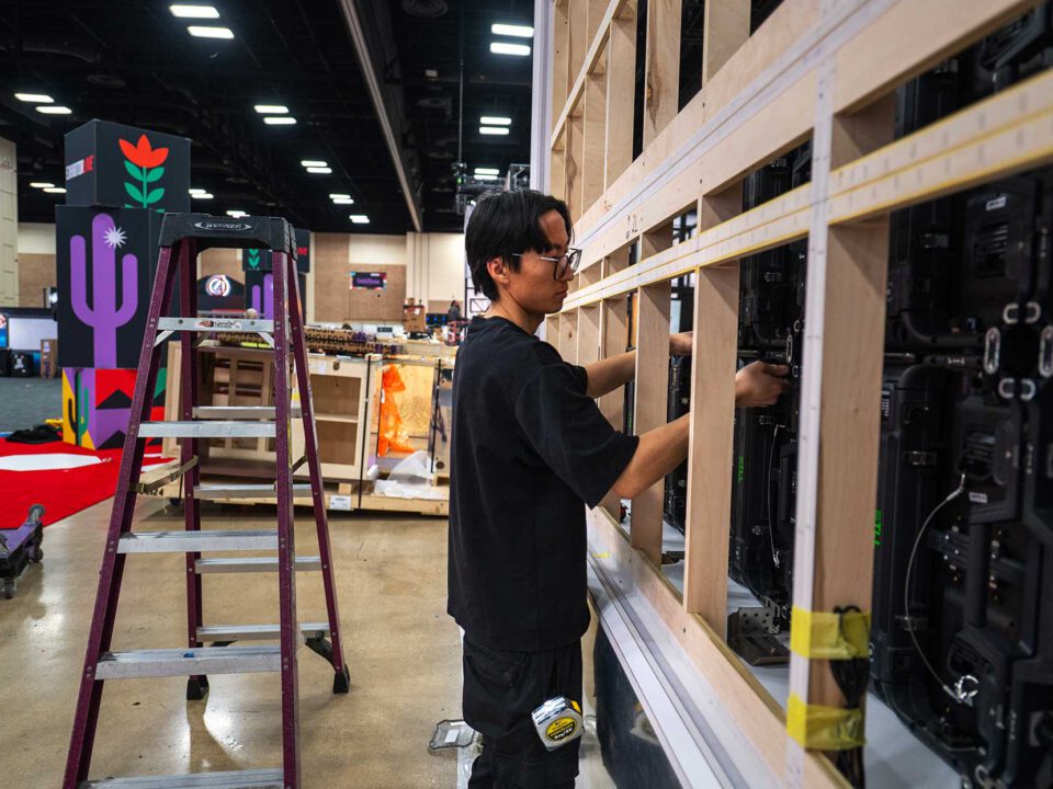 Exhibit Installation ExhibitorLive of a large LED Screen, anchored by a temporary wooden wall.