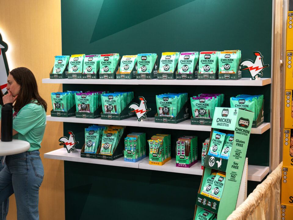 A Mighty Spark branded product packaging shelving, reminiscent of a pop-up store front display at ExpoWest 2026.